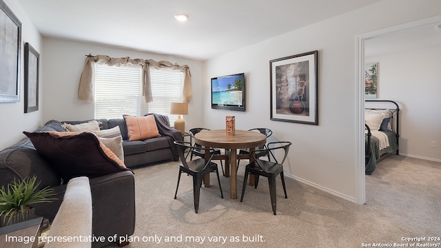dining space with baseboards and light carpet