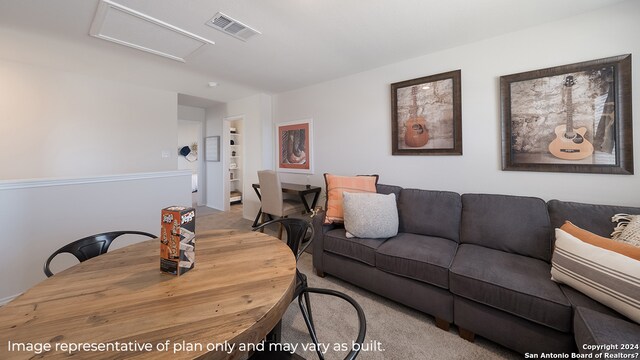 living area featuring attic access, visible vents, and carpet flooring