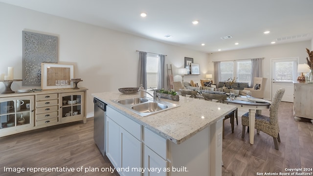 kitchen featuring stainless steel dishwasher, a sink, open floor plan, wood finished floors, and an island with sink