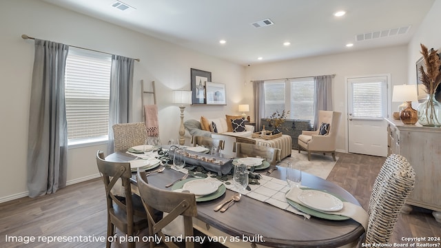 dining area with wood finished floors and visible vents