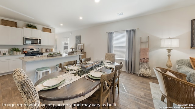 dining room featuring recessed lighting, light wood-style floors, visible vents, and plenty of natural light