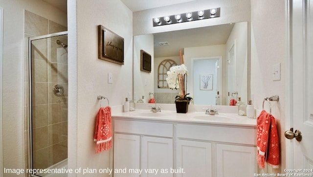 full bath featuring a stall shower, double vanity, and a sink