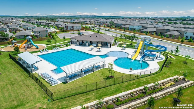 pool with fence, a water slide, a patio, and playground community