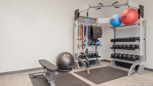 workout area featuring wood finished floors and baseboards
