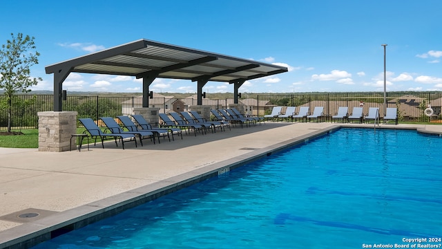 pool with a patio and fence