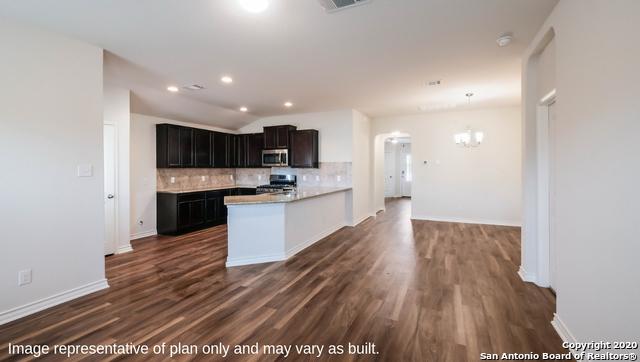 14614 Clay Ridge Run, San Antonio, TX 78253 - kitchen with stainless steel microwave, stove, backsplash, a chandelier, and light countertops