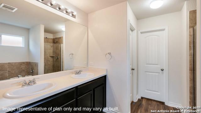 14614 Clay Ridge Run, San Antonio, TX 78253 - bathroom with a tile shower, double vanity, and wood finished floors