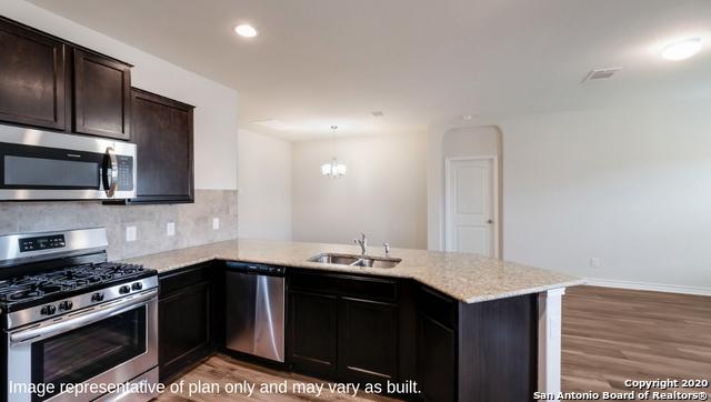 14614 Clay Ridge Run, San Antonio, TX 78253 - kitchen with appliances with stainless steel finishes, a sink, a peninsula, light wood-type flooring, and recessed lighting