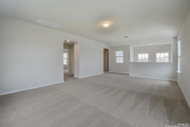 12127 Jasper Strm, San Antonio, TX 78245 - empty room with arched walkways, vaulted ceiling, light carpet, and baseboards