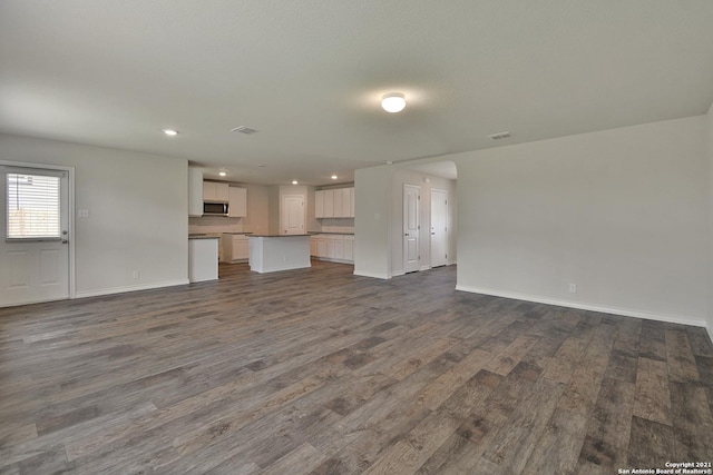 12127 Jasper Strm, San Antonio, TX 78245 - unfurnished living room featuring dark wood-type flooring, baseboards, and recessed lighting