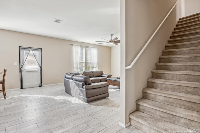 staircase with baseboards, wood finished floors, and ceiling fan