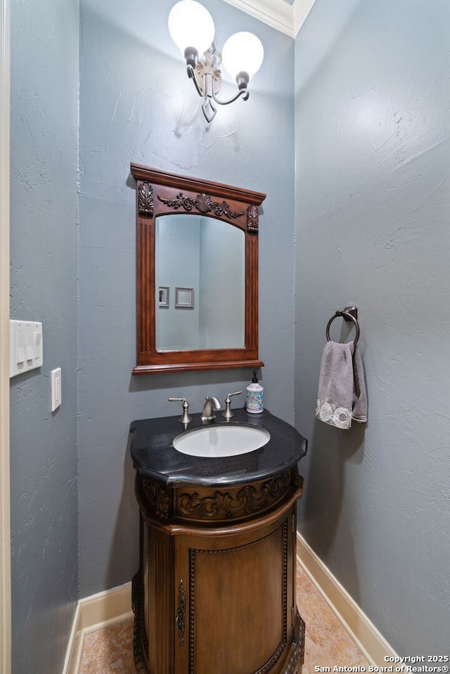 bathroom with baseboards, tile patterned floors, vanity, and ornamental molding