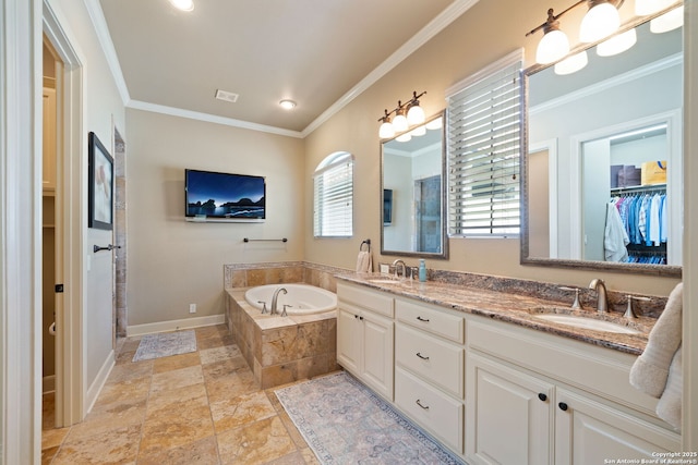 full bathroom with stone tile floors, a garden tub, a sink, and ornamental molding