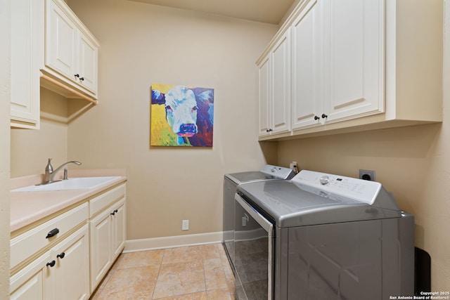 laundry room with baseboards, independent washer and dryer, a sink, and cabinet space