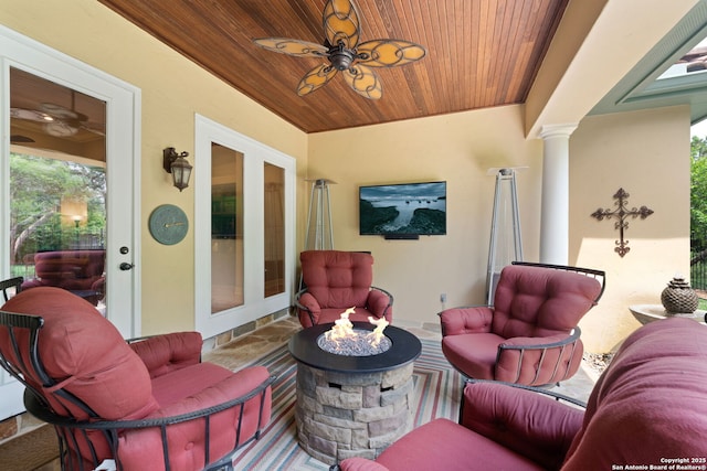 exterior space with stone tile flooring, ornate columns, a ceiling fan, and wooden ceiling