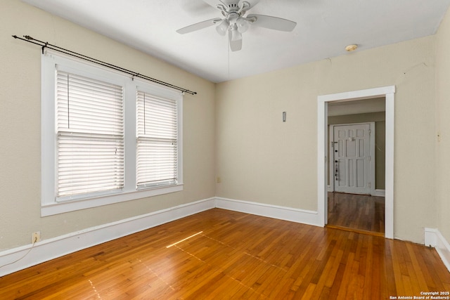 empty room with ceiling fan, baseboards, and hardwood / wood-style floors