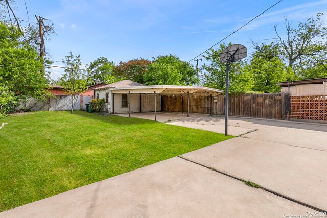 exterior space with a detached carport, fence private yard, and a yard