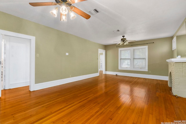 unfurnished living room featuring baseboards, a ceiling fan, hardwood / wood-style floors, and visible vents