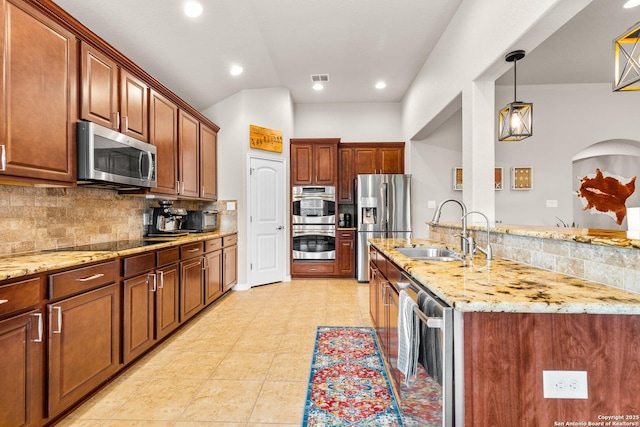 kitchen with light stone countertops, beverage cooler, stainless steel appliances, and a sink