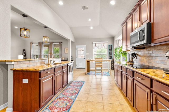 kitchen with lofted ceiling, plenty of natural light, visible vents, tasteful backsplash, and appliances with stainless steel finishes