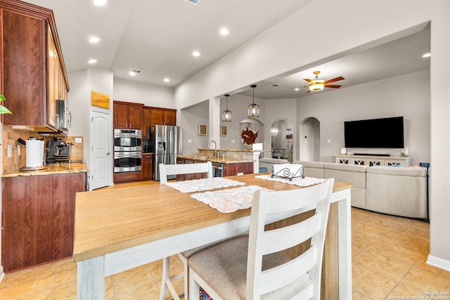 dining area with a ceiling fan, arched walkways, recessed lighting, and light tile patterned floors