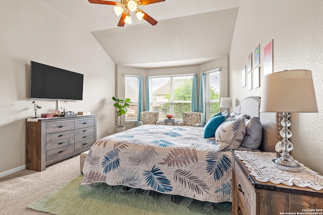bedroom featuring carpet flooring, vaulted ceiling, baseboards, a ceiling fan, and a textured wall