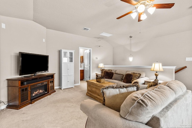 living area featuring baseboards, visible vents, lofted ceiling, ceiling fan, and carpet floors
