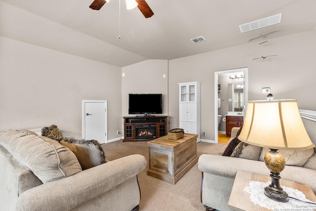 living room featuring light carpet, vaulted ceiling, visible vents, and ceiling fan