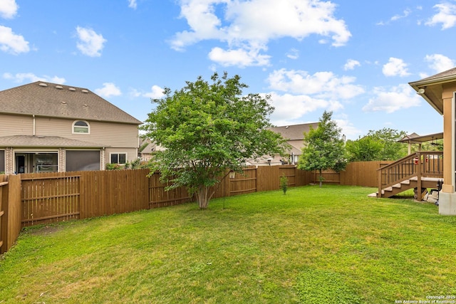 view of yard featuring a fenced backyard and stairs