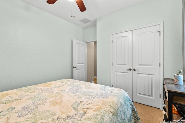 carpeted bedroom with ceiling fan, visible vents, and a closet