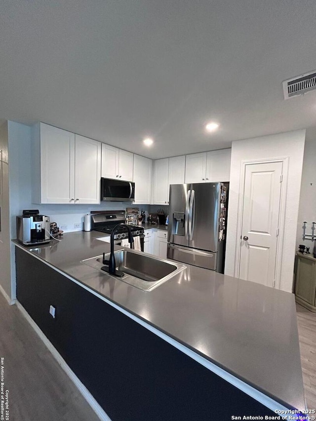 5936 Forenoon, Bulverde, TX 78163 - kitchen featuring a sink, visible vents, stainless steel appliances, light wood-style floors, and a peninsula