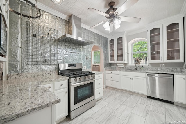 1923 W Pyron Ave, San Antonio, TX 78211 - kitchen with a sink, stainless steel appliances, crown molding, wall chimney exhaust hood, and arched walkways