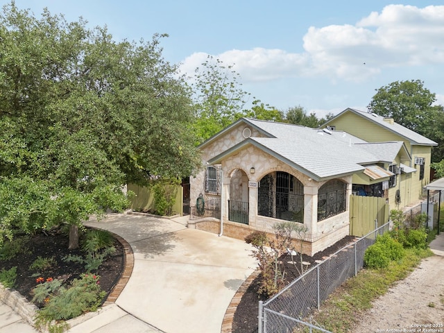 1923 W Pyron Ave, San Antonio, TX 78211 - view of front of home with fence private yard, roof with shingles, and stone siding