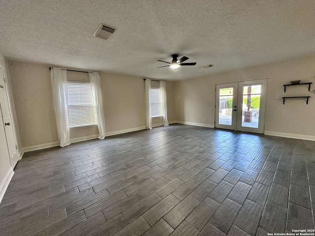 spare room with wood tiled floor, visible vents, french doors, a textured ceiling, and ceiling fan