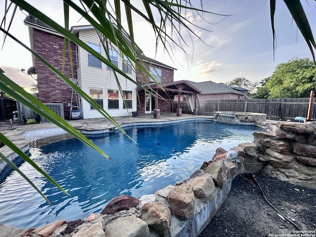 view of pool with a fenced backyard, central AC unit, a patio, and a pool with connected hot tub