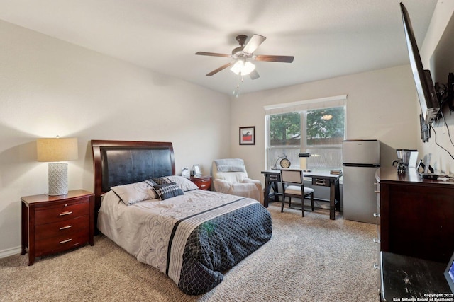 carpeted bedroom with freestanding refrigerator and ceiling fan