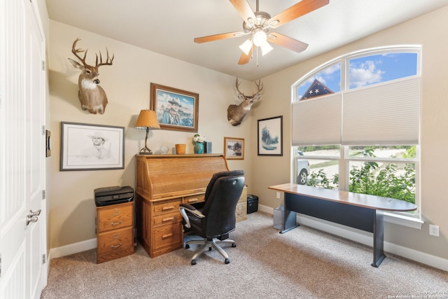 office with a ceiling fan, baseboards, and light colored carpet