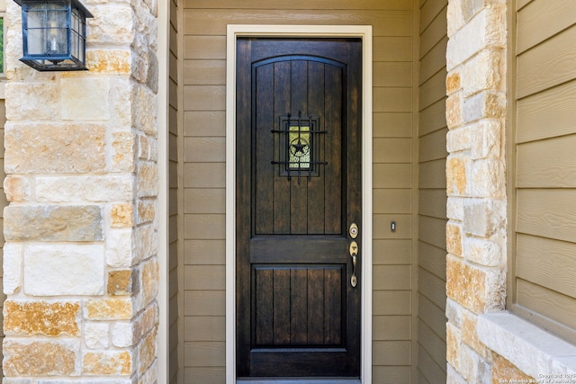 property entrance with stone siding