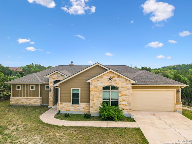 view of front of house featuring stone siding, concrete driveway, a garage, a shingled roof, and a front yard