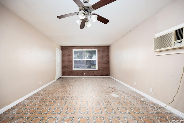spare room featuring brick wall, baseboards, ceiling fan, and a wall unit AC