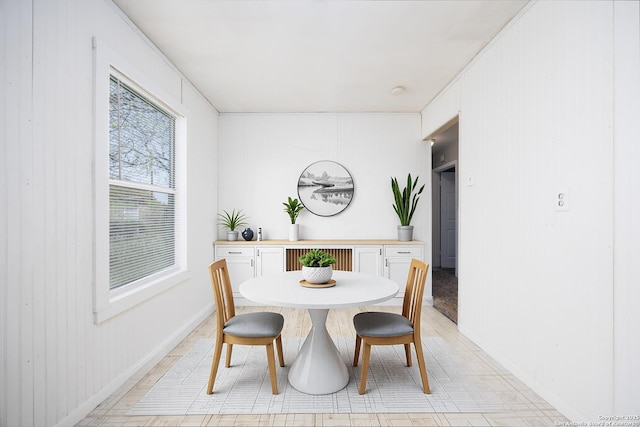dining area with baseboards and wood walls