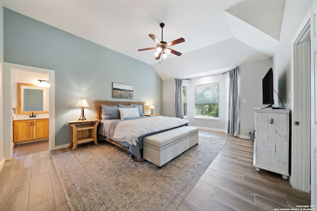 bedroom with lofted ceiling, a ceiling fan, baseboards, light wood-style flooring, and ensuite bathroom