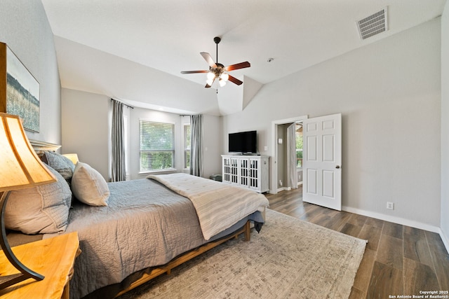 bedroom featuring a ceiling fan, wood finished floors, baseboards, lofted ceiling, and visible vents