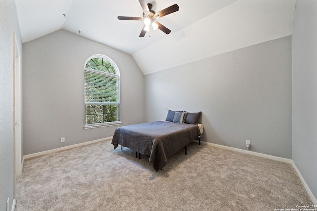 carpeted bedroom with ceiling fan, vaulted ceiling, and baseboards