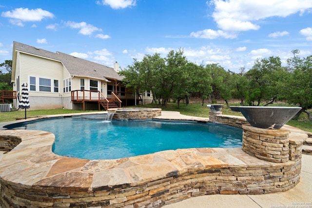 view of swimming pool featuring a wooden deck, a pool with connected hot tub, stairs, and central air condition unit