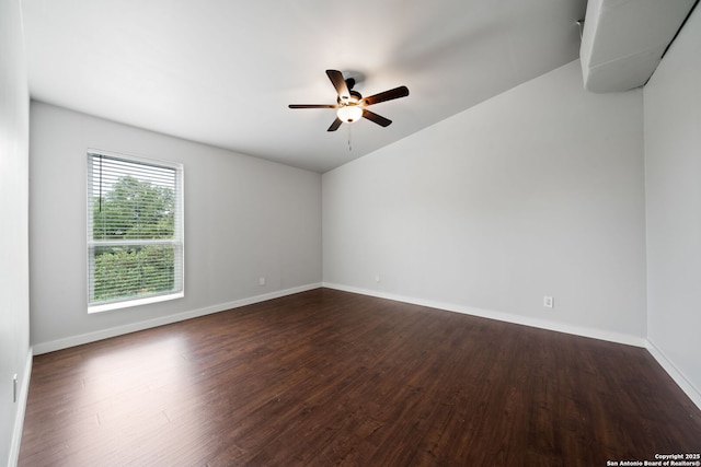 unfurnished room featuring baseboards, dark wood-type flooring, and ceiling fan