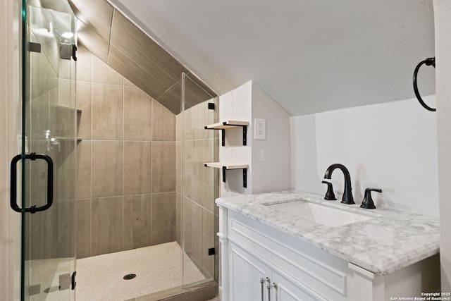 full bathroom featuring vaulted ceiling, vanity, and a stall shower