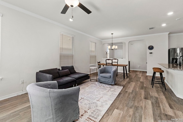 8212 Mulaney, San Antonio, TX 78253 - living room featuring ceiling fan with notable chandelier, wood finished floors, crown molding, and visible vents
