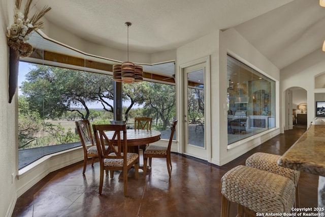 dining room featuring arched walkways and baseboards