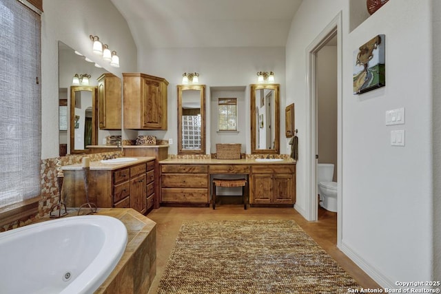 bathroom featuring a bath, wood finished floors, vanity, and toilet